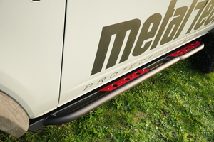 Close-up of black and red Sidewinder rock slider installed on the lower side of a 2021 Bronco 4-door.