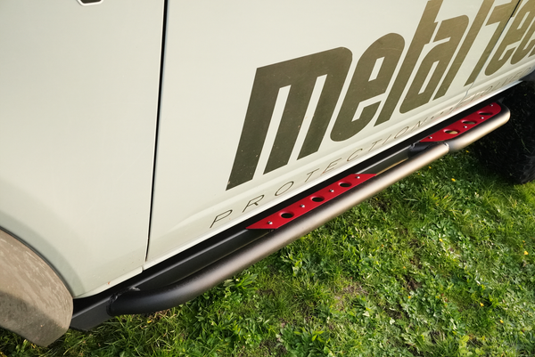Close-up of black and red Sidewinder rock slider installed on the lower side of a 2021 Bronco 4-door.