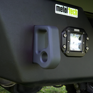 Close-up of black Cerakote-finished aluminum rear bumper pull point mounted next to a square off-road light.