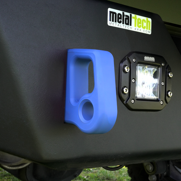 Close-up of blue aluminum rear bumper pull point with Cerakote finish installed next to a black off-road light.