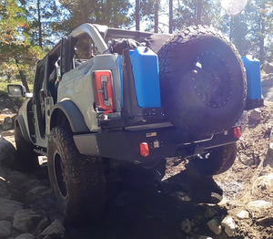 Off-road Ford Bronco with Metal Tech 4x4 rear Aces High bumper, spare tire, and blue fuel cans mounted.