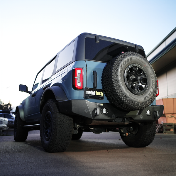 Rear view of blue Bronco 6G with Metal Tech 4x4 high rear bumper and spare tire mounted.