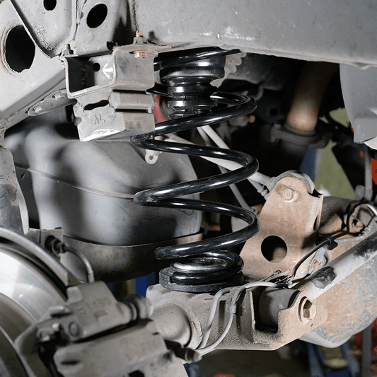 Close-up of Metal Tech 4x4 GX460 rear coil spring conversion installed at stock height with key cones.