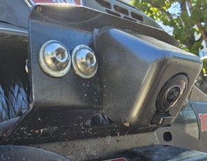 Close-up of Bronco 6G front camera relocation kit mounted with bolts on vehicle bumper bracket.