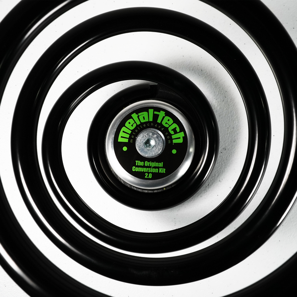 Close-up of black Metal Tech rear coil spring with branded center cap for GX460 coil conversion kit.