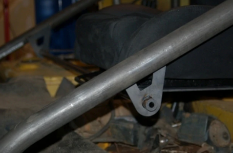 Close-up of Metal Tech FJ40 Land Cruiser seat cradle system showing metal frame attachment point and seat base.