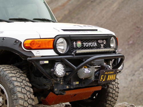 Front view of white Toyota FJ Cruiser with black Metal Tech tube bumper and off-road lights installed.