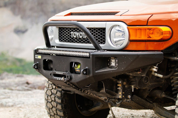 Close-up of black Metal Tech Phantom front bumper installed on orange Toyota FJ Cruiser with winch and LED light bar.