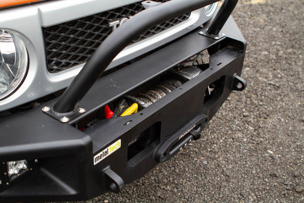 Close-up of black Metal Tech Phantom front bumper with winch installed on silver Toyota FJ Cruiser.