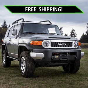 Toyota FJ Cruiser with Metal Tech Stronghold winch bumper installed on grassy field under cloudy sky.
