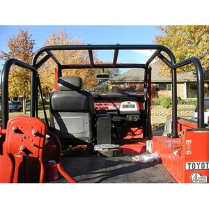 Interior view of red FJ40 Land Cruiser with installed black Jackson roll cage kit and single front seat.