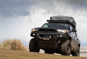 Front view of 5th Gen 4Runner with Metal Tech Fortress front bumper installed, off-road setting with roof tent.