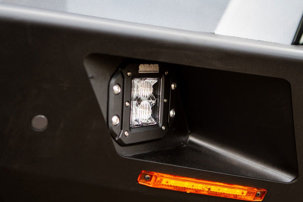 Close-up of black metal front bumper light housing with dual LED lights and amber reflector on Lexus GX460.