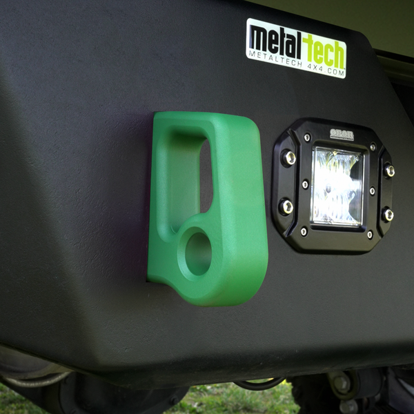 Green aluminum rear bumper pull point with Cerakote finish installed next to a black off-road light on a vehicle.