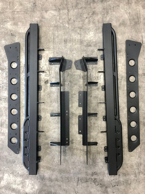 Flat lay of black metal rock sliders and mounting brackets for Lexus LX570 on concrete floor.