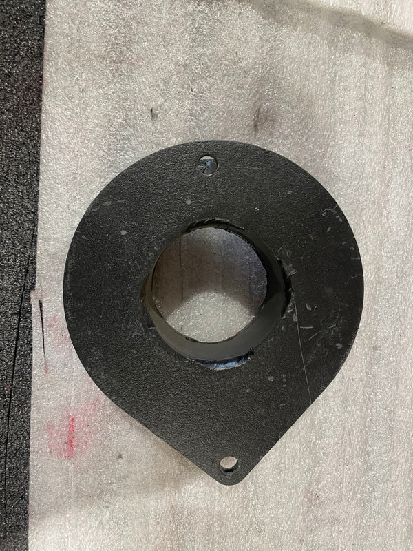 Top-down view of a black metal front spacer plate with two mounting holes, showing minor surface scratches.