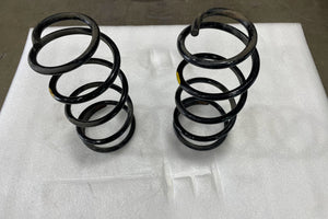 Pair of black rear coil springs for GX470, GX460, FJ Cruiser, and 4Runner on white foam background.