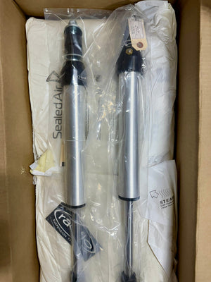 Pair of Radflo 2.0 IFP rear shocks for Prado 120/150, silver with black accents, inside open shipping box.