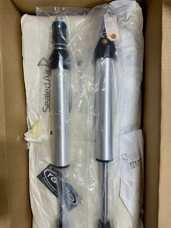 Pair of Radflo 2.0 IFP rear shocks for Prado 120/150, silver with black accents, inside open shipping box.