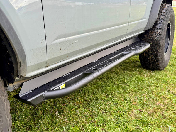 Close-up of black Metal Tech rock slider installed on 2021 Ford Bronco 4-door, showing textured step and mounting.