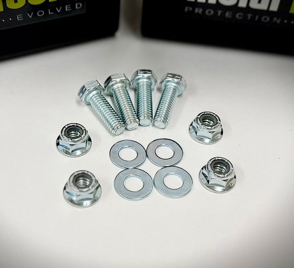 Four silver bolts, four washers, and four nuts arranged on a white surface for rear bump stop installation.
