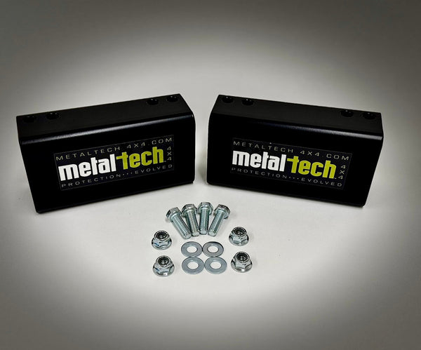 Two black Metal Tech rear bump stop drop blocks with bolts, nuts, and washers for FJ Cruiser and 4Runner long travel suspension.