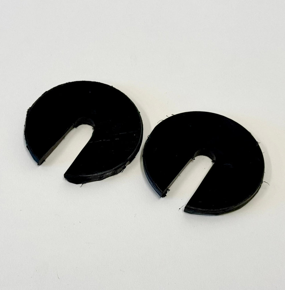 Two black 1/4-inch thick circular body mount shims with a slot cut out, shown on a white background.