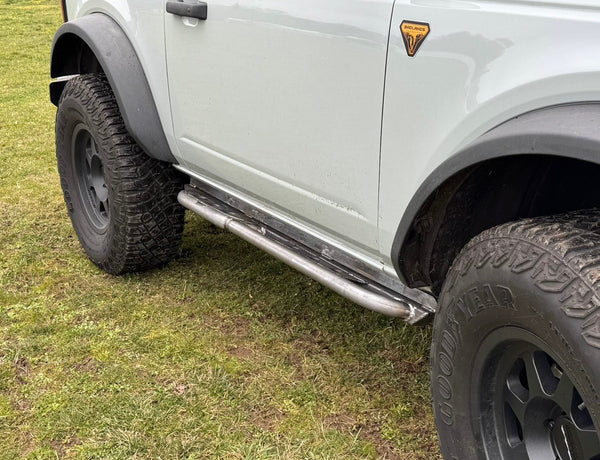 Close-up of metal Sidewinder RRR rock sliders installed on the driver side of a 2021 Ford Bronco 2-door.