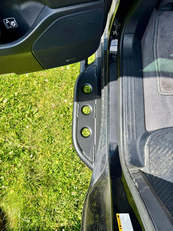 Close-up of black metal rock slider installed on 2008-2021 Toyota Land Cruiser door sill area.