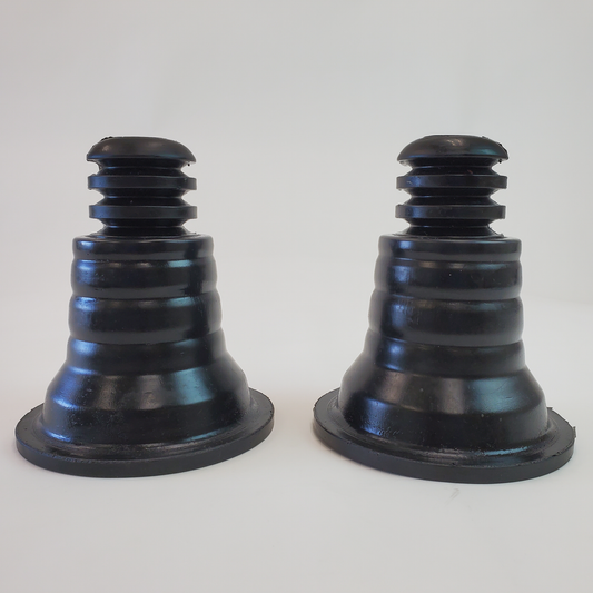 Pair of black rubber rear spring upper isolators with stepped cone design for 4x4 suspension systems.