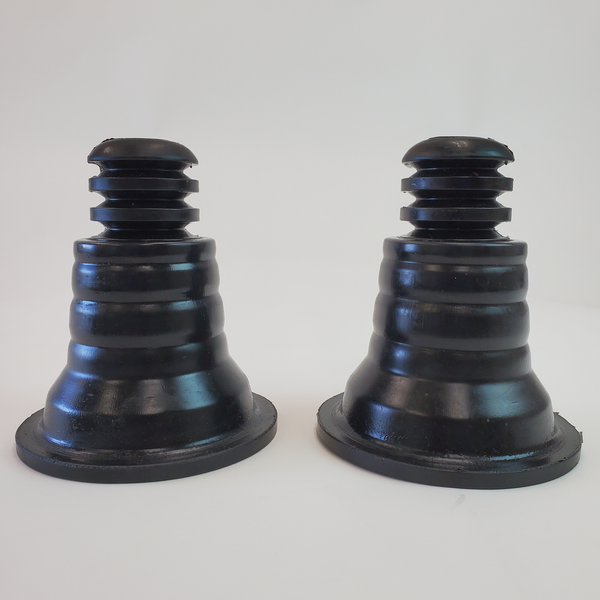 Pair of black rubber rear spring upper isolators with stepped cone design for 4x4 suspension systems.
