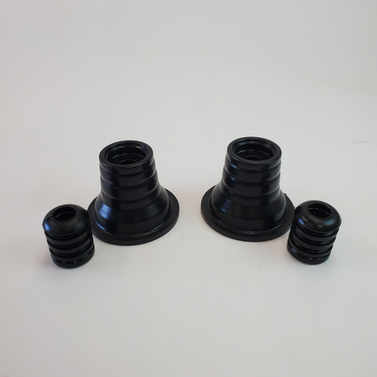 Pair of black rubber rear spring upper isolators and smaller cone-shaped isolators for 4x4 suspension systems.