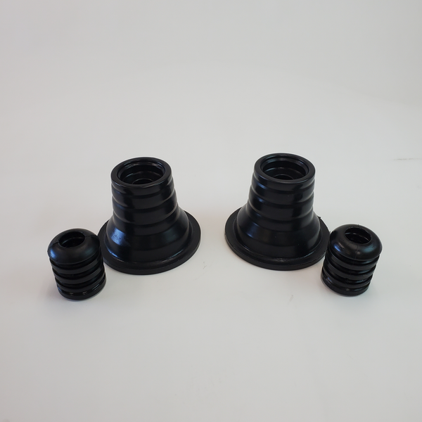 Pair of black rubber rear spring upper isolators and smaller cone-shaped isolators for 4x4 suspension systems.