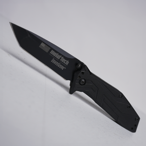 Black Metal-Tech 4x4 custom Kershaw folding knife with textured handle and partially serrated blade.