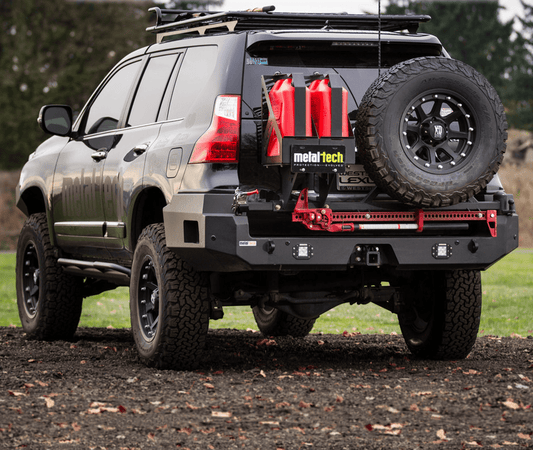 Rear view of black Lexus GX460 with Metal Tech rear swing-out bumper, spare tire, and red fuel cans mounted.