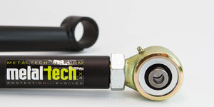 Close-up of Metal Tech 3rd Gen 4Runner rear lower link with black tube and gold-toned rod end bearing.