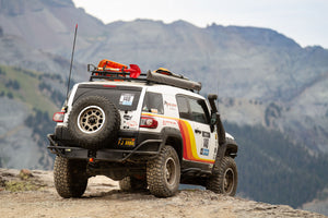 Rear view of white FJ Cruiser with Metal Tech rear tube bumper on rocky mountain trail.