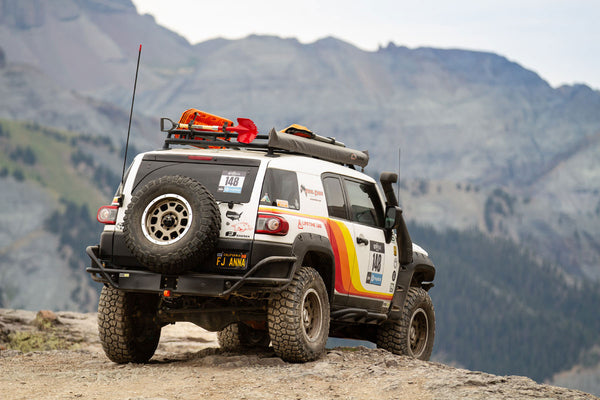 Rear view of white FJ Cruiser with Metal Tech rear tube bumper on rocky mountain trail.