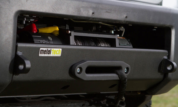 Close-up of Metal Tech Stronghold winch bumper installed on FJ Cruiser, showing integrated winch and synthetic rope.
