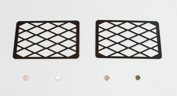 Two black metal winch hole covers with diamond pattern and four small round magnets on white background.
