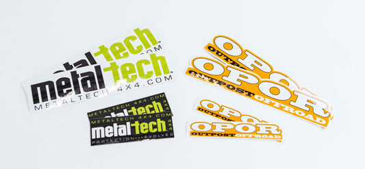 Set of Metal Tech and OPOR Outpost Offroad stickers in black, white, green, and orange colors on a white background.