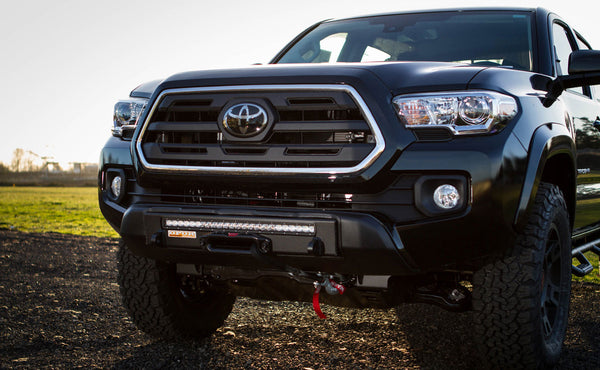 Front view of 2016 Toyota Tacoma with black Stronghold winch bumper and LED light bar installed.