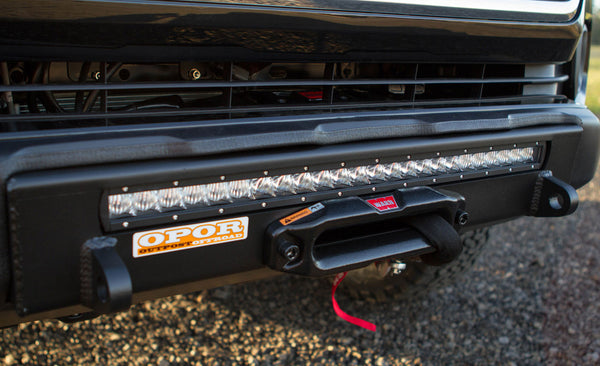 Close-up of black Stronghold winch bumper with integrated LED light bar installed on 2016 Tacoma front end.