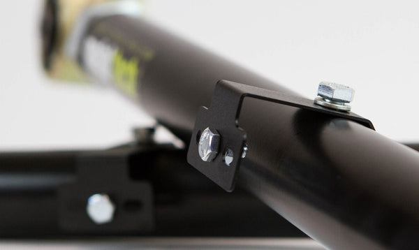 Close-up of black metal offset rear lower link with mounting bracket and bolts for Lexus GX470/GX460 suspension.