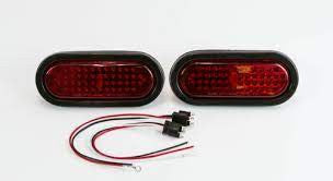 Pair of oval red LED tail lights with wiring harness for FJ40 Land Cruiser, shown on white background.
