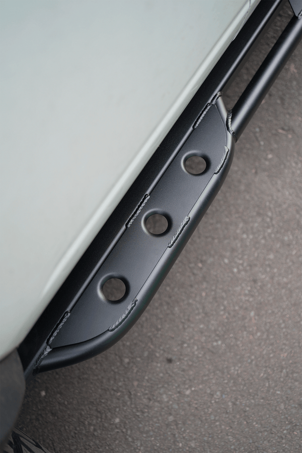 Close-up of black Sidewinder RRR rock slider installed on 2021 Ford Bronco 2-door, showing welded construction and holes.