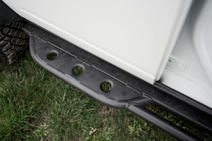 Close-up of black metal rock slider installed on 2021 Ford Bronco 4-door, showing welded details and mounting points.