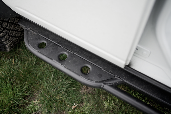Close-up of black metal rock slider installed on 2021 Ford Bronco 4-door, showing welded details and mounting points.