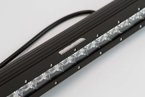 Close-up of a black 150W single-row LED light bar with 30 lenses and attached wiring harness.