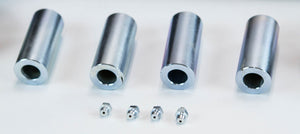 Four cylindrical metal spacers with four small grease fittings arranged below on a white surface.
